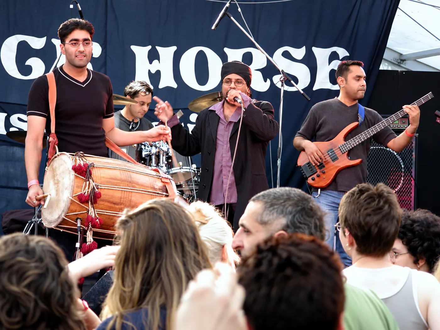 Dhol player and band performing above a festival crowd